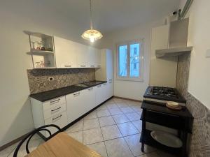 a kitchen with white cabinets and a stove top oven at LA CASA DEI FIORI - S. LORENZO in Rome