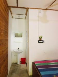 a bathroom with a sink and a toilet in a room at Walkers hostel in Trincomalee