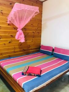 a room with a bed with a pink umbrella at Walkers hostel in Trincomalee