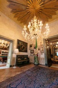 a living room with a chandelier and a fireplace at Palazzo Doria Napoli in Naples
