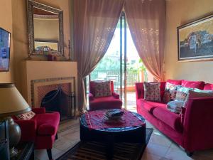 sala de estar con sofá rojo y chimenea en AbirKech appartement en Marrakech