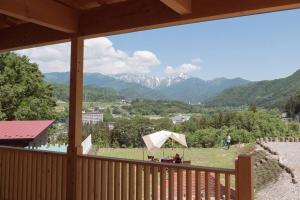 a balcony with a view of a mountain range at 山が見える貸切コテージ「WIND+HORN」 