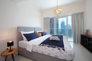 a bedroom with a large bed and a large window at Panoramic Marina View 2BR Suite Damac Heights in Dubai