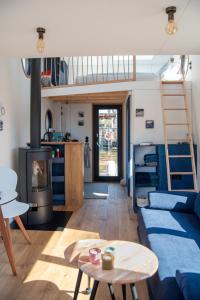 漢堡的住宿－Undine - Wunderschönes Tiny Hausboot，客厅设有蓝色的沙发和梯子