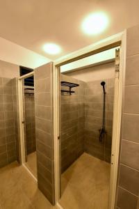 a walk in shower with a glass door in a bathroom at Oceans Explore Hostel in Green Island