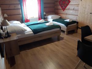 a bedroom with two beds and a desk and a window at Pokoje Gościnne Iwona in Brzegi