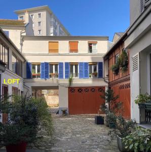 un edificio con persiane blu e un garage rosso di Loft character with a view of court a Parigi