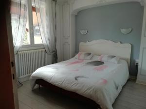 Un dormitorio con una cama blanca con flores rosas. en chez Patrice et Gilda, en Albi