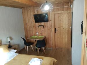 a room with a desk and a bed and a tv at Pokoje Gościnne Iwona in Brzegi
