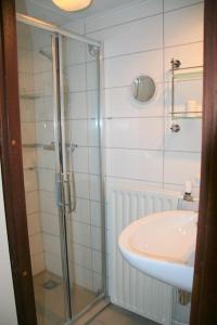uma casa de banho com uma cabina de duche em vidro e um lavatório. em Lepelblad 37* em Nieuwvliet