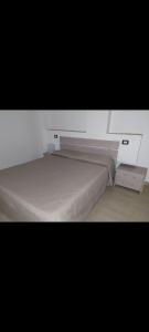um quarto com uma cama grande e uma parede branca em Heidi em Villabate