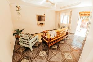 ein Wohnzimmer mit einer Bank und einem Stuhl in der Unterkunft Casa tamanho família com Garagem, Churrasqueira e Redes de Descanso in Búzios