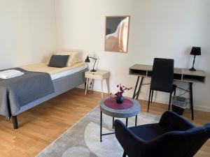 um quarto com uma cama, uma mesa e um piano em RS Lägenhetshotell Skövde em Skövde