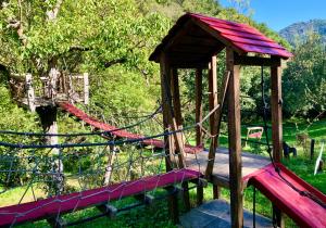 a wooden playground with a slide in a park at Apartamentos Rurales & Spa La Bárcena in Enterria