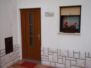una porta di un edificio con finestra e vaso da fiore di Sobe Vera a Bovec