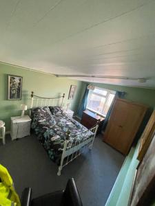 Schlafzimmer mit einem Bett und einem Fenster in der Unterkunft Heath Farm cottage in Newport