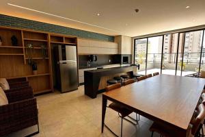 eine Küche mit einem Tisch und eine Küche mit einem Kühlschrank in der Unterkunft Apartamento 2 quartos, St Bueno Parque Vaca Brava in Goiânia