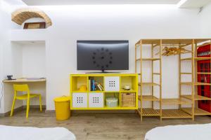 un centro de entretenimiento amarillo con TV en la parte superior en I Della en Milán