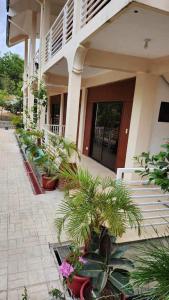 a building with potted plants in front of it at Flores Garden Hotel in Coron