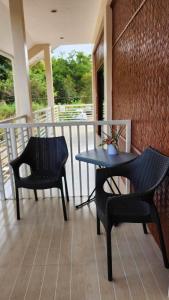 Flores Garden Hotel في كورون: بلكونه فيها كرسيين وطاولة وكراسي