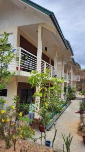 a house with a lot of plants in front of it at Flores Garden Hotel in Coron