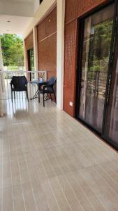 a patio with a table and chairs and a table and chairs at Flores Garden Hotel in Coron