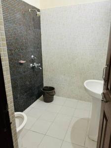 uma casa de banho com um chuveiro, um WC e um lavatório. em Its a spacious penthouse em Chandīgarh