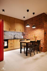 a kitchen with a table and a brick wall at Zarębisko - noclegi całoroczne in Zwierzyniec