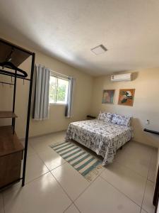 um quarto com uma cama e uma janela em Casa Recanto dos Guaiamuns - Carneiros PE em Sirinhaém