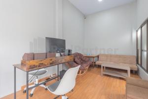 a living room with a couch and a table and chairs at Rumah Panda Guesthouse RedPartner in Tangkil