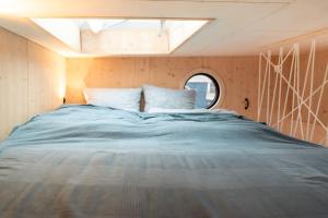 a large bed in a small room with a window at Dein Hausboot OFF für deine Auszeit in Hamburg in Hamburg