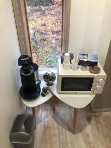 une petite cuisine avec une table et un four micro-ondes dans l'établissement Chambre chez l'habitant, à Châteauvieux