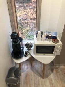 a small kitchen with a table with a microwave at Chambre chez Myriam et Arnaud in Châteauvieux