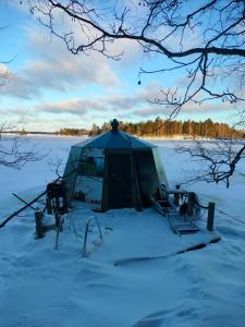 a tent in the snow in a snowy field at Aurora Hut Savonlinna in Savonlinna
