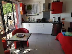 a kitchen with white cabinets and a table in a room at Lucky Lemons - Boutique Houses Madeira (Studio) in Calheta