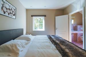 a large bed in a bedroom with a window at Le Brocard in Durbuy
