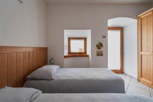 a bedroom with two beds and a window at Pietra Rara Apartments in Pietramurata