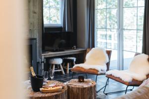 a living room with two chairs and a table with food at Le Brocard in Durbuy