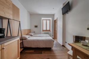 a bedroom with a bed and a tv on a wall at Pietra Rara Apartments in Pietramurata