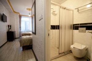 a bathroom with a toilet and a shower and a bedroom at Golden Horn Park Hotel in Istanbul