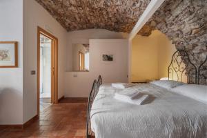 um quarto com uma cama grande e uma parede de pedra em Pietra Rara Apartments em Pietramurata
