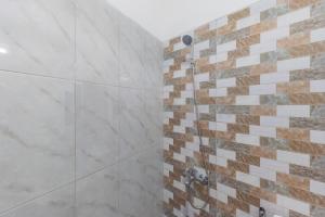 a bathroom with a shower with marble tiles at Rumah Panda Guesthouse RedPartner in Tangkil