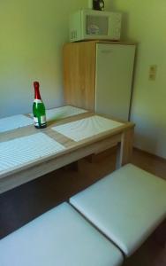a bottle sitting on top of a table with a refrigerator at 4 Personen Ferienwohnung in Hohnstein