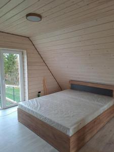 A bed or beds in a room at Svečių namelis
