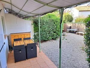 eine Terrasse mit einem Tisch und einer Bank unter einem Baldachin in der Unterkunft NOUVEAU! Maison 2 pcs mezzanine dans résidence avec piscine in Tourrettes