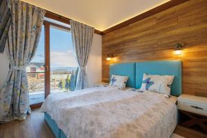 a bedroom with a bed and a large window at Mountain villa Jordan- with JACUZZI in Razlog
