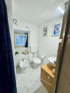 bagno bianco con servizi igienici e lavandino di Loft Pantano, Catania Center Villa Bellini a Catania