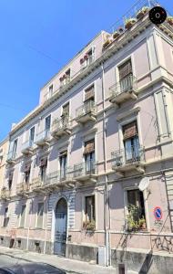 un grande edificio bianco con balconi su strada di Loft Pantano, Catania Center Villa Bellini a Catania