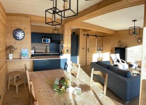 a kitchen and living room with a table and a couch at LA PERLE DES CAILLOUX EXCEPTIONNEL et COSY in Font Romeu Odeillo Via