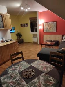 a living room with a table and a kitchen at Apartmán Orbit in Karlov